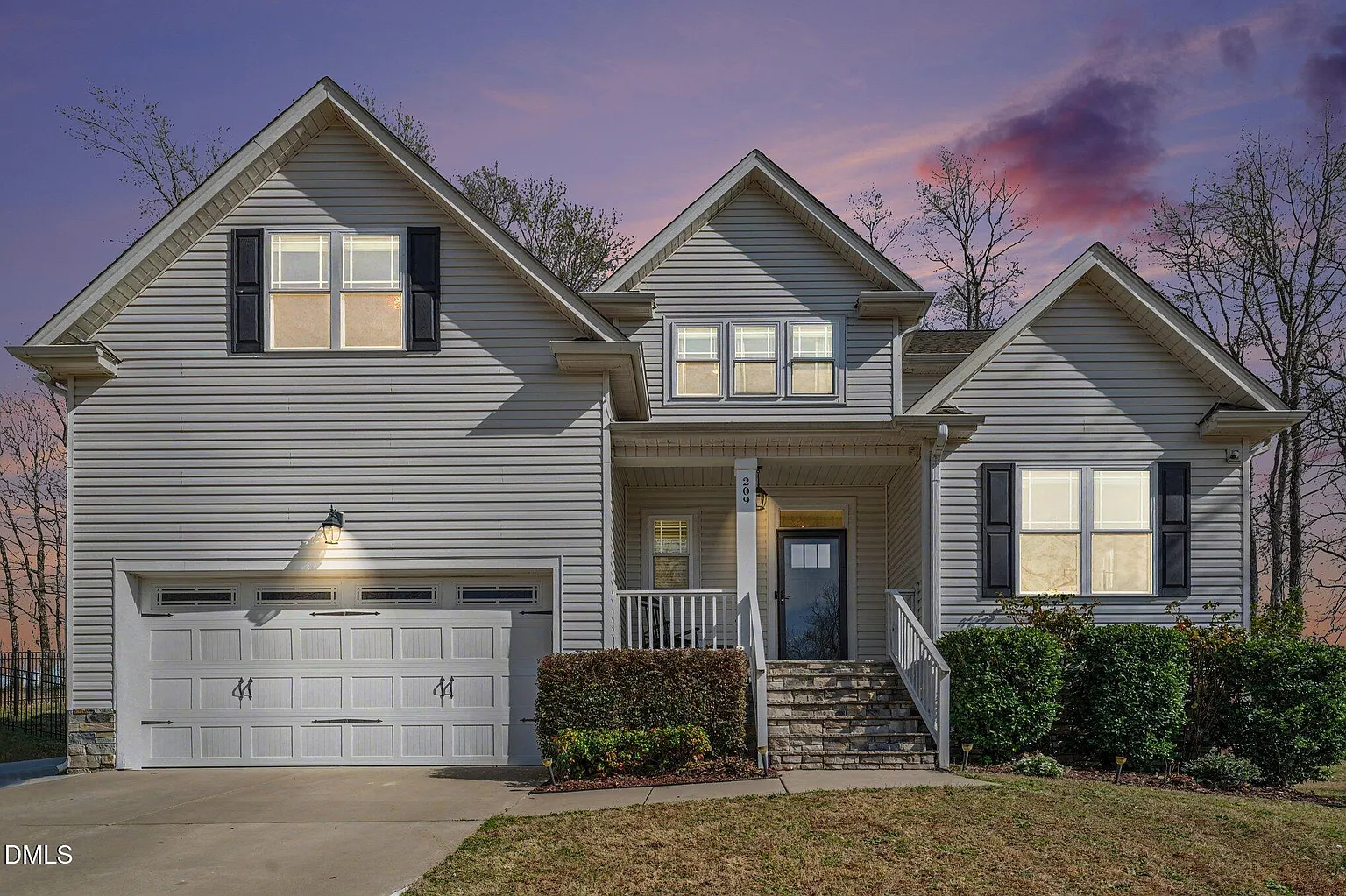 Elegant stone-stepped entrance with covered front porch