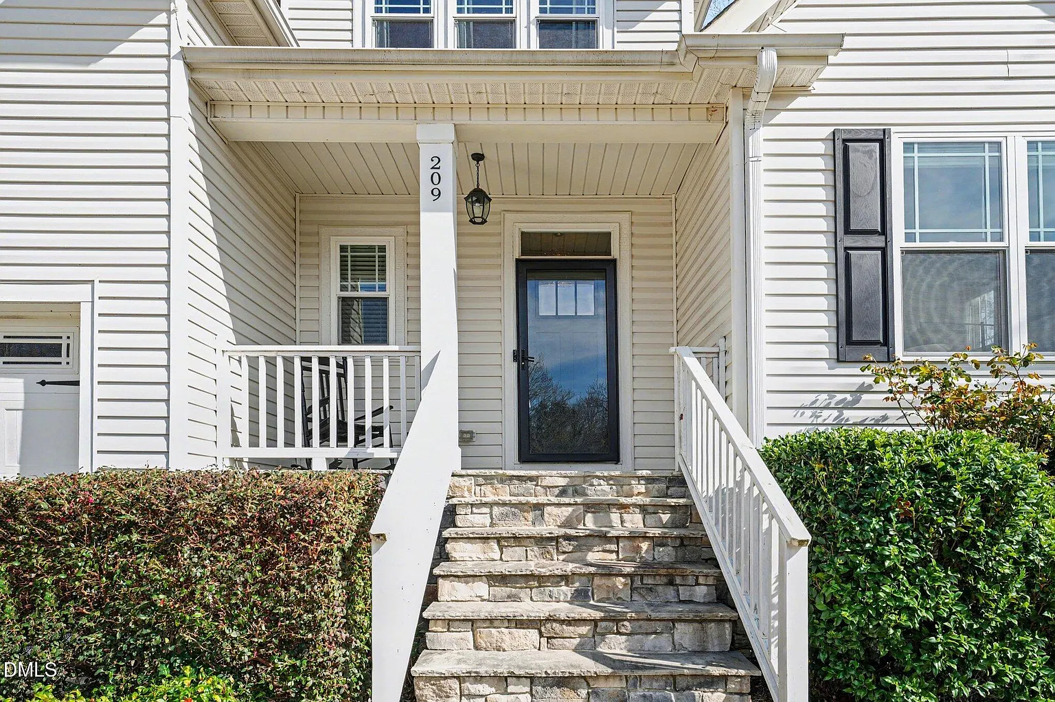 Welcoming covered entry with stone steps and modern door