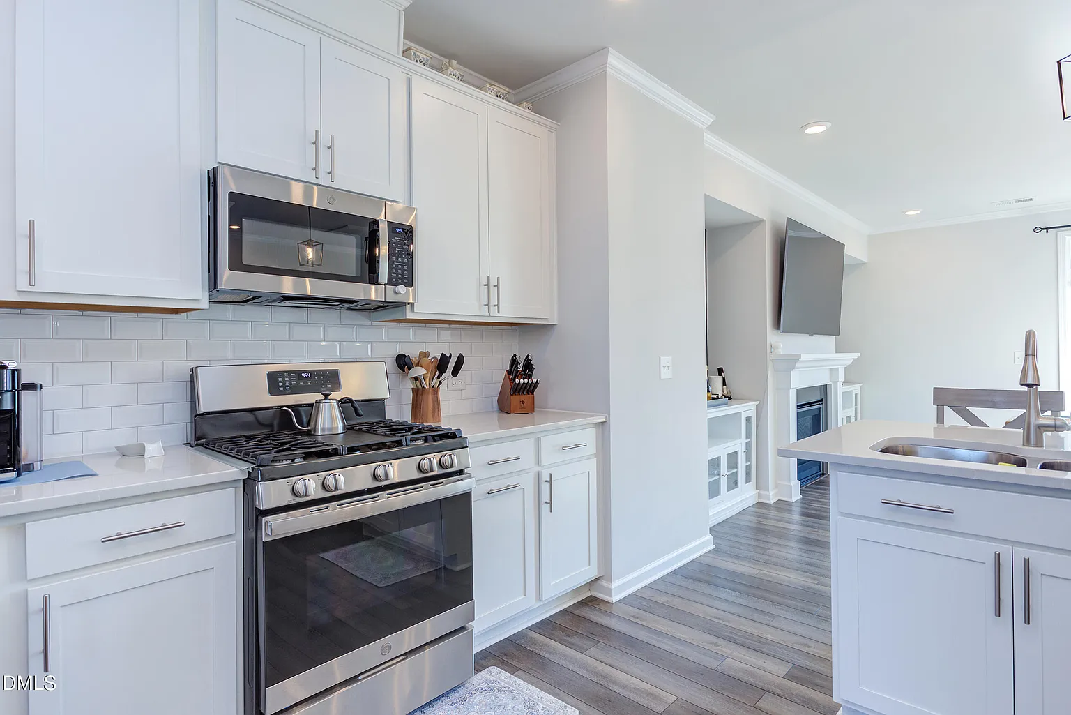 Gourmet kitchen with white cabinetry and subway tile