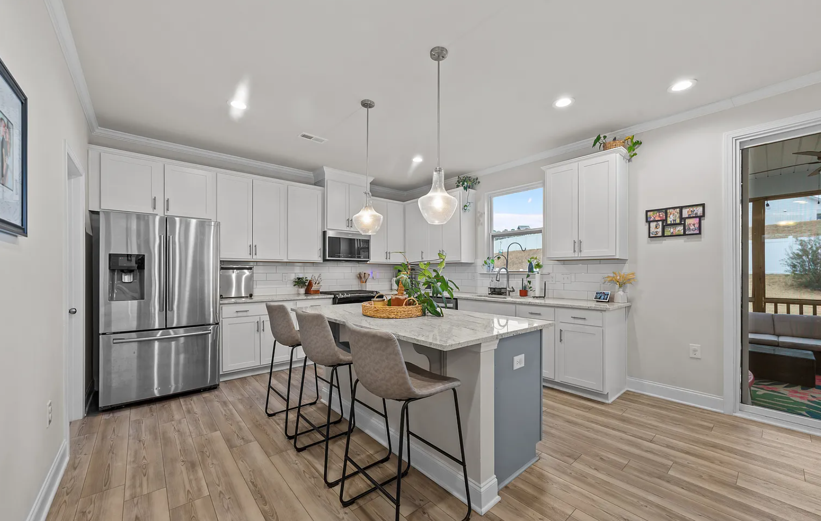 Gourmet kitchen featuring white cabinetry and oversized marble island